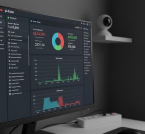 Uma imagem de um dashboard do Pi-hole (ou similar) mostrando gráficos de tráfego de rede e domínios bloqueados, com uma tomada inteligente ou câmera Wi-Fi no fundo.