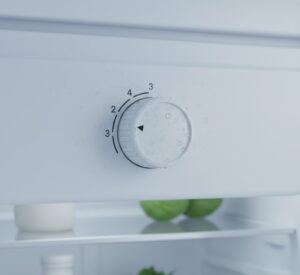Close-up do botão de controle de temperatura de uma geladeira doméstica.
