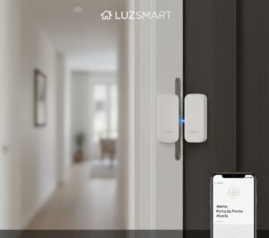 Sensor de porta e janela Aqara instalado em uma porta branca parcialmente aberta, mostrando os dois componentes magnéticos separados. Um smartphone na parte inferior direita exibe o aplicativo com uma notificação "Alerta: Porta da Frente Aberta".